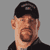 Static pixelated image of a man's face and upper torso wearing a black cap and dark shirt against a gray background.