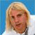 A pixelated image of a person with blonde hair and a white top, set against a blue background with text elements.