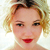 Pixelated close-up of a person with light brown hair styled in an updo, wearing red lipstick and a white pearl necklace against a light background.