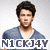 Pixelated image of a person with dark hair and a beard wearing a blue V-neck shirt against a light background with text below.