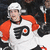 Pixelated image of a person wearing white helmet and orange-and-white sports jersey with black 'PH' logo on chest, standing against dark background.