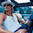 A 48x48 pixel buddy icon featuring a cartoon-style character in a white tank top and light blue hat against a blurred background, with green text reading "Original Icons .com" on the right side.