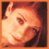 Four pixelated facial expressions of a person with reddish-brown hair in an orange-bordered , showing smiling, winking, laughing, and side-eye poses
