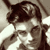Pixelated grayscale image of a person's face with dark hair and light skin tones, rendered in low-resolution 256x256 pixels with visible dithering and blocky artifacts.