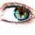 A static image showing a close-up of an eye with green and brown hues, a colorful striped tag reading LOVE, and two kissing figures in pink and blue.