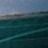 Pixelated static image of a calm ocean scene with layered blue and green tones, showing water extending to a distant horizon under a muted sky.