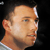 Static pixelated close-up of a person's face and neck against black background with partial white collar visible.