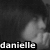 Pixelated grayscale image of a person with dark hair and light skin, partially obscured by shadow, with the name 'danielle' in white lowercase letters at the bottom.