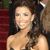 A pixelated close-up of a person with long dark hair, wearing a strapless top, against a blurred background with red and brown tones.