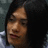 A pixelated image of a person with dark hair and light skin, accompanied by text elements on black background.