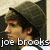 Pixelated profile image of a person with dark hair wearing a military-style cap, set against a muted background with text below.