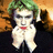 Pixelated static image of a character with green hair, white face, red lips, and dark clothing against a gradient background.