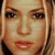 Pixelated close-up of a person's face with light brown hair, showing eyes, nose, mouth, and partial cheeks in warm tones.