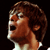 Pixelated profile view of a person with brown hair and light skin, mouth open in a shout or yell against a black background.