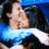 Two people embrace in a close-up pose with a blue gradient background and text reading 'Embrace the Clock!' below.