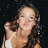 A pixelated image of a person with long dark hair wearing a white sleeveless top against a black background.