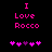 Pixelated pink text "I Love Rocco" on black background with two of five pixel hearts below, one showing a purple heart in the third position