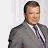 A 48x48 pixel buddy icon featuring a man in a gray suit with text elements arranged across four quadrants of the image.