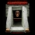 Pixelated static image of a white and red structure with a dark interior containing a small face-like figure.