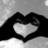 Black and white pixelated image showing hands forming a heart shape on the left, transitioning to a '<3' symbol on the right.
