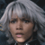 Pixelated close-up of a person with light gray hair, neutral expression, and visible mouth, set against a dark background.