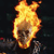 A pixelated image of a skull engulfed in bright orange and yellow flames against a dark background.