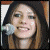 Animated contact sheet of four frames showing a person with long brown hair holding a microphone, with the word "AVRIL" in pixelated text at bottom right.