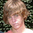 A pixelated image of a person with light brown hair against green foliage, surrounded by pink <3 symbols and text on blue background.