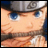 Pixelated close-up of a character's face with blue eyes, light skin tone, and dark hair under a gray headband.