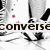 Black-and-white image of a person's lower legs and feet in Converse sneakers with red accents, text elements change across frames.