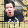 A person in a black shirt with white circular design appears against yellow background, mouth open in surprise