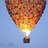 A hot air balloon with a flame burner against a blue sky, next to a yellow background with pixelated text reading 'thing is impossi believe in what' and two small gray squares.