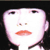 Pixelated face with wide eyes, small nose, and red lips against black background.