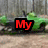Green vehicle with black accents on a dirt path, featuring red text overlays reading 'My' and 'Love<3' against a wooden fence background.