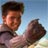 Static 48x48 pixel icon showing a person holding an object against a blue sky background with visible pixelation and dithering effects.