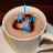 A cup of coffee with a heart-shaped latte art design, overlaid with blue text reading "I love it when you keep me warm <3" across four