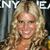 A pixelated image of a person with long, wavy blonde hair, wearing a light-colored top, with partial text 'NY' and 'E' visible in the background.