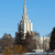 Pixelated static image of a tall, narrow building with a spire against a clear blue sky, surrounded by lower structures.