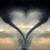 A heart-shaped icon with a mirrored background showing a cloudy sky and distant horizon, displayed in a