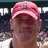 A pixelated image shows a person wearing a pink cap with a blue emblem, standing in front of a blurred crowd background.