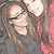A person with long brown hair and glasses wears a dark gray top against a red and gray background, with visible pixelation.