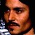 Pixelated close-up of a person's face with warm skin tones, dark eyes, and a neutral expression against a dark background.