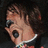Pixelated close-up of a person with dark hair, wearing sunglasses and a white-collared shirt with colorful patterns.