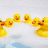 Yellow rubber ducklings in a line on a light background with pink text reading 'i love duckies' below them.
