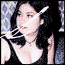 A pixelated animated sequence shows a woman with dark shoulder-length hair wearing a black sleeveless top and choker necklace against a blue patterned background, holding a white object near her face.
