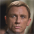 Pixelated close-up of a person's face with light brown hair, blue eyes, and a neutral expression against a blurred background.