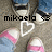 Pixelated image of a character with dark hair and blue eyes, wearing a white top with pink accents, holding a white heart shape.