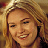 Pixelated close-up of a smiling person with light brown hair and warm skin tones, rendered in low-resolution 48x48 pixels with visible dithering and color blending.
