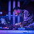 Pixelated blue and purple abstract composition with vertical and horizontal lines, a central pinkish shape, and scattered light patches on dark background.
