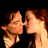 Pixelated static image of two people kissing with brown hair and light skin tones against a black background.